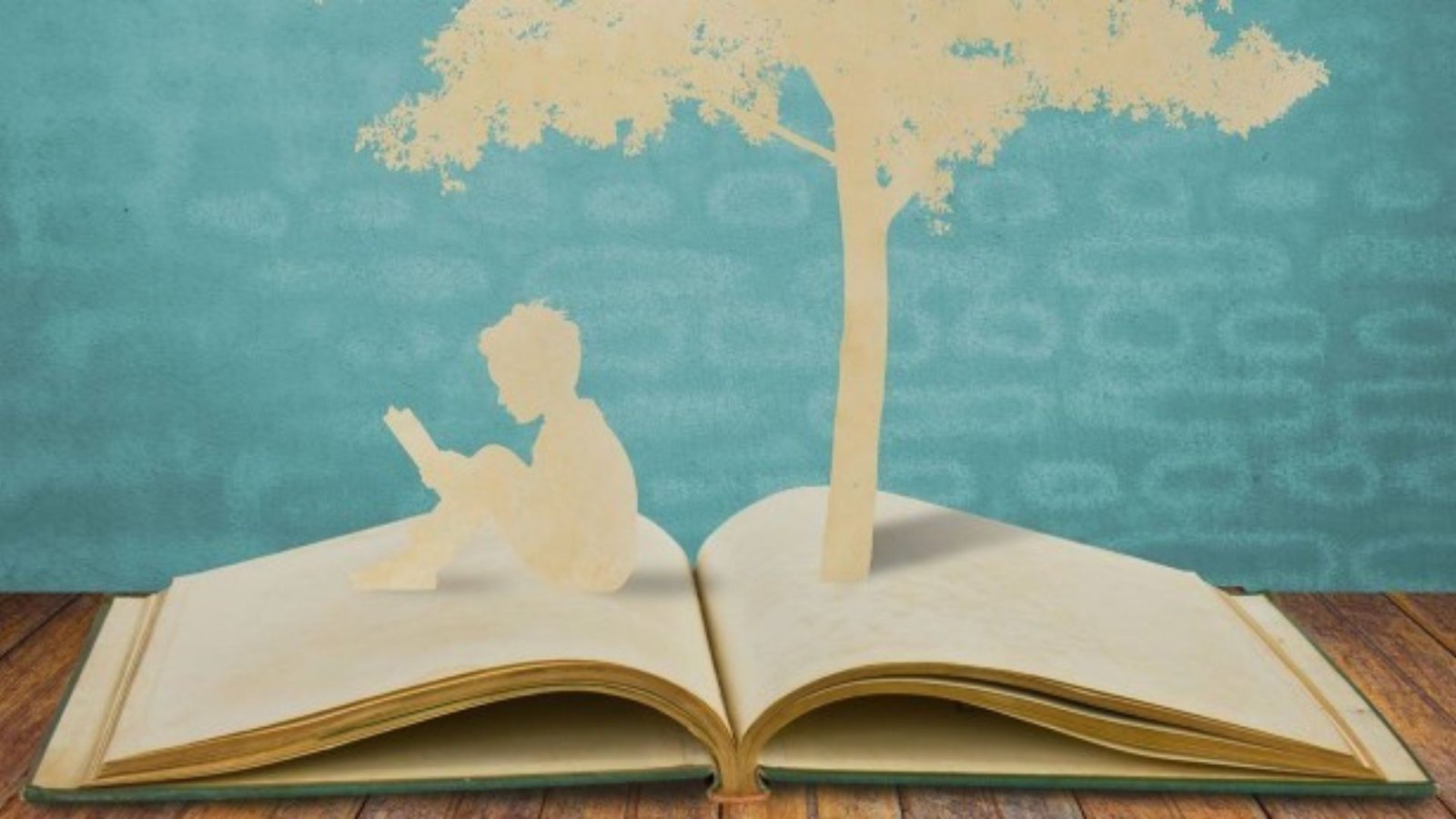 a person sitting on a book and a tree on top of the book